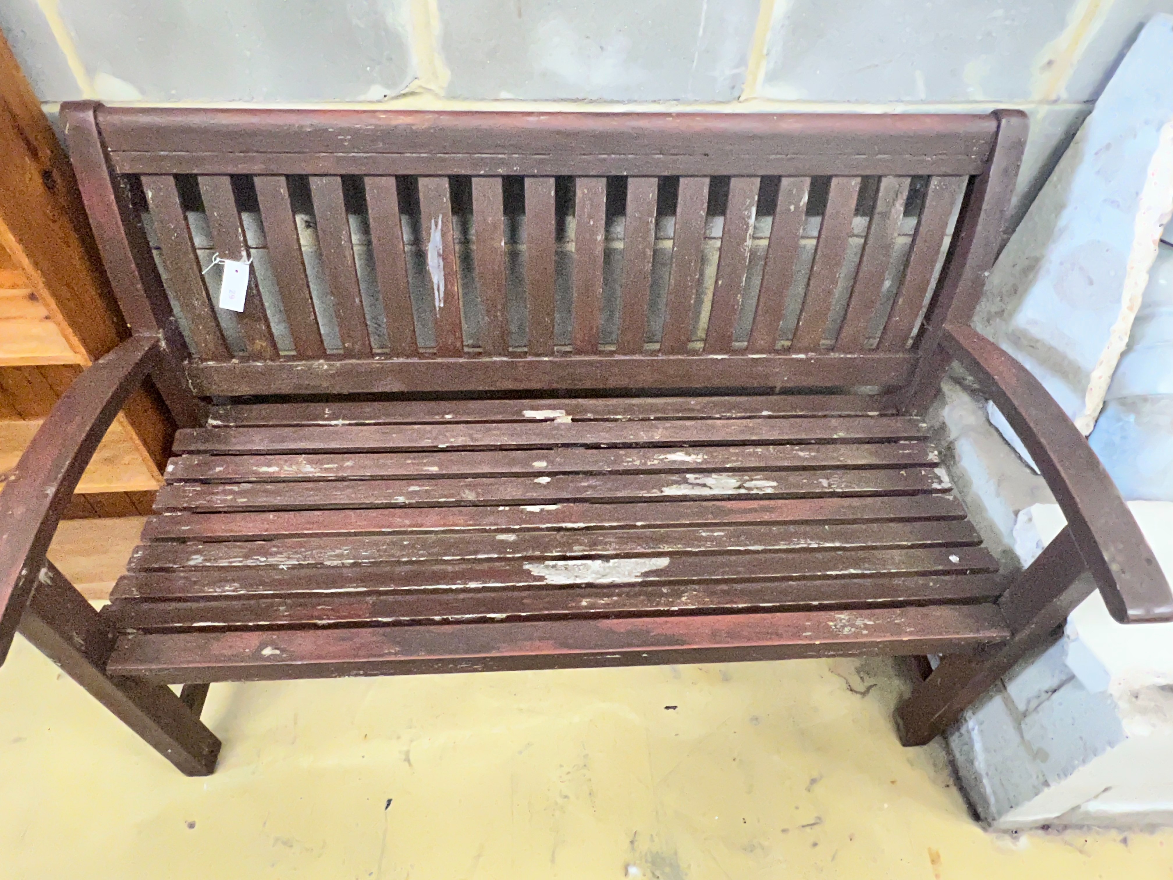 A stained teak slatted garden bench, 138 x 58cm height 92cm